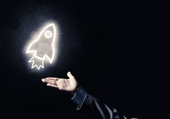 Man palm presenting Rocket web icon as technology concept