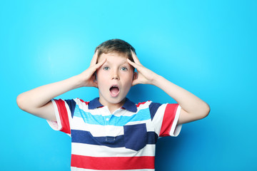 Portrait of emotional boy on blue background