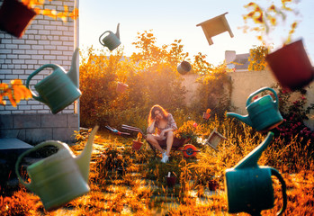 Garden concept. Young woman gardener sits on wheelbarrow and garden tools fly around her. Perfectly...