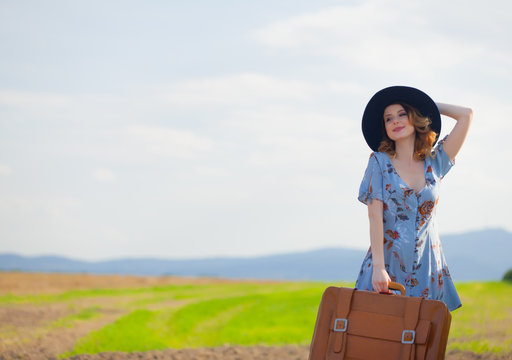 woman at countryside with suitcase