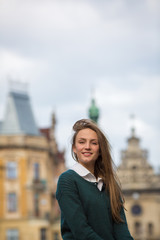 Smiling young woman looking camera on old city background