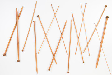 Fototapeta na wymiar Variety of wooden knitting needles in different sizes on white background