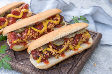 Hot Dog with grilled bacon wrapped sausage, ketchup, yellow mustard, fried onion and pickles