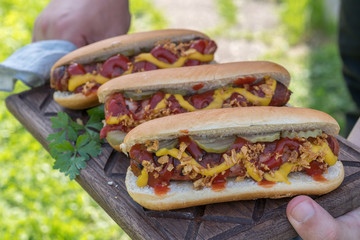 Hot Dog with grilled bacon wrapped sausage, ketchup, yellow mustard, fried onion and pickles