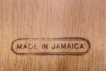 Obraz premium A piece of wood with a burnt engraving on the lower side with the words Made in Jamaica. 