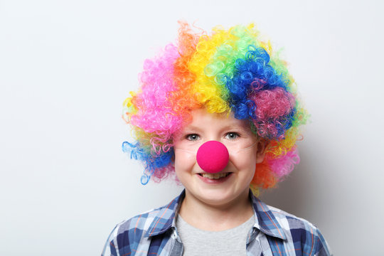 Portrait of  little boy clown on grey background