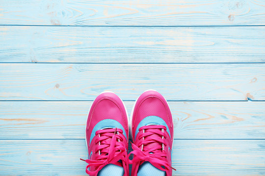 Pink sport shoes on blue wooden table