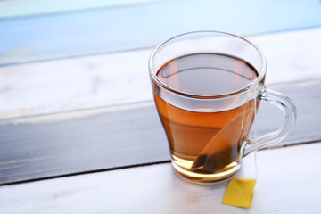 Cup of tea with teabag on wooden table