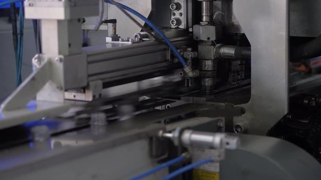 The process of blowing plastic bottles in extrusion equipment. Molten white plastic like a tube is placed in a press form and blowing the air and is give to shape of the bottle.Beverage factory