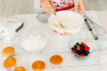Young girl making cream for cupcakes.