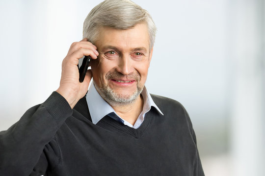 Smiling Mature Man With Phone. Portrait Of Grey Hair Man Holding Phone Near Ear Close Up.