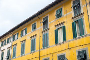 Fototapeta premium Yellow Building with Green Windows in city of Pisa, Italy.