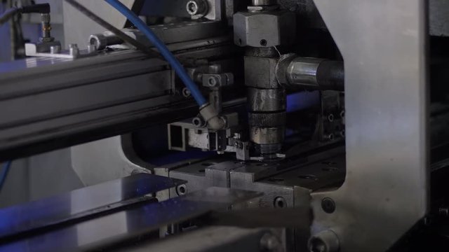 The process of blowing plastic bottles in extrusion equipment. Molten white plastic like a tube is placed in a press form and blowing the air and is give to shape of the bottle.