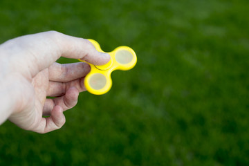 Man to play with Fidget Spinner in his hands, the concept of relieving stress, develop a small hand mathematics.