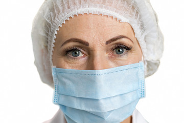 Detail of female mature doctor. Female white-skin doctor close up wearing mask, white background. Medical and healthcare concept.