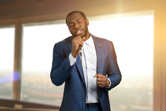 Jazzman singing on sunlight background. Beautiful perfomance of black arist. Talanted afro american jazz singer.