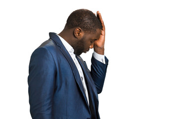 Businessman with closed eyes and headache. Beard black manager touching his head with hand, side photo. Dissapointed and frustrated afro american businessman feeling headache.