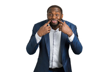 Young businessman making face. Portrait of businessman making a forced smile by his hands while...