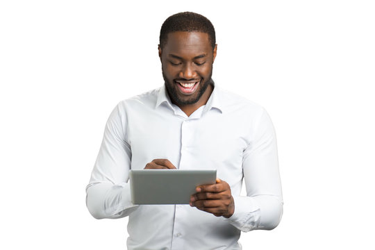 Elated businessman using pc tablet. Happy afro american entrepreneur working on touch screen tablet on white background.