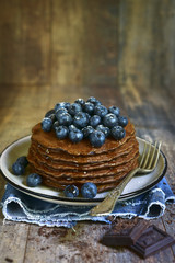 Homemade chocolate pancakes with fresh blueberry and honey.