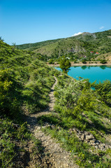 Fototapeta na wymiar Mountain path to the village along the lake