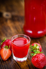 Wooden table with Strawberry liqueur, selective focus