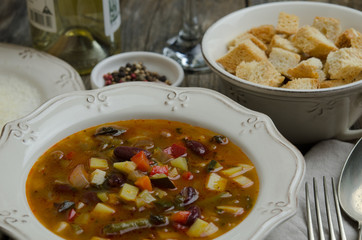 Vegetables soup served with croutons, rustic background 