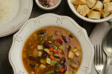 Vegetables soup served with croutons, rustic background 