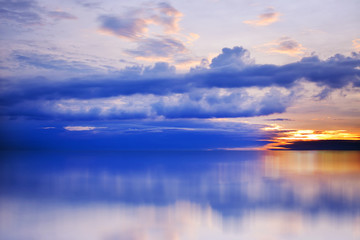 Bright, colorful sunset over the sea, blue sky, rich cloud
