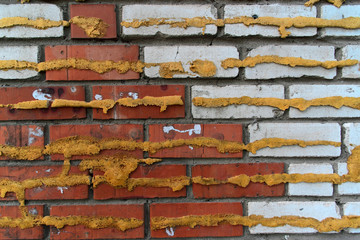 Wall of red and white bricks with Spray foam