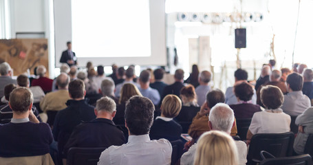 Speaker giving a talk in conference hall at business event. Audience at the conference hall....