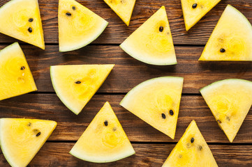yellow watermelon slices on dark old wooden background top view