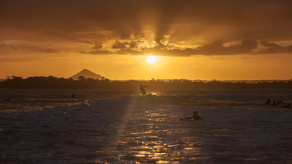 Surfer riding wave at sunset. backlit