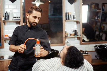 Barber spreading perfume on client