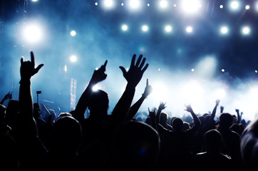 silhouettes of concert crowd in front of bright stage lights