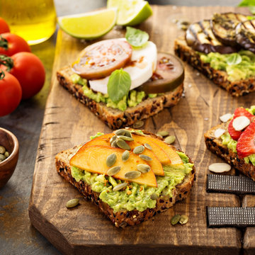 Variety of avocado toasts on a cutting board