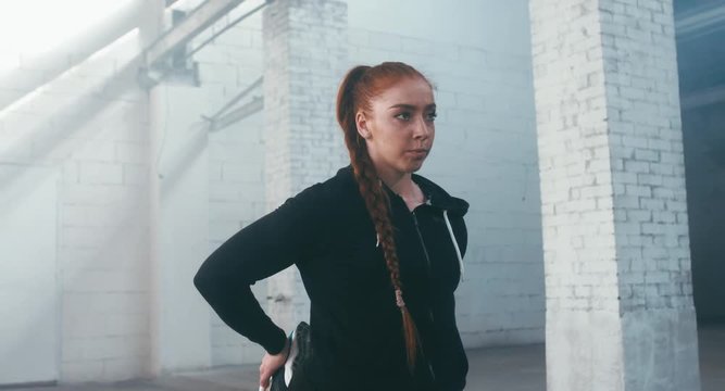 CU Caucasian female in sport outfit stretching before martial arts training. 4K UHD, 60 FPS SLO MO