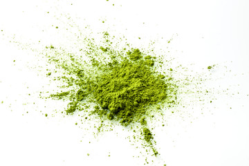 Matcha powder explosion on white background from above. Matcha is made of finely ground green tea powder. It's very common in japanese culture. Matcha is healthy due to it's high antioxydant count. - obrazy, fototapety, plakaty