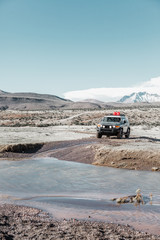 vehículo todoterreno cruzando un arroyo en el altiplano. Chile