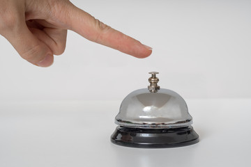 Hand is ringing silver service bell on white background.