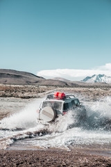 Vehículo todoterreno cruzando un arroyo en el desierto de Chile.