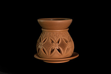 Isolated terracotta stove for aromatherapy on black background