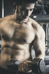 Fototapeta na wymiar Asian man raising Dumbbell Black color has handsome body good healthy Indoor exercise in gym.