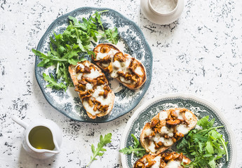 Hot sandwiches with mushrooms and mozzarella on a light background, top view. Delicious appetizer or snack