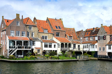 View from the bridge in Enkhuizen traditional old brick buildings with tile roofs, Netherlands