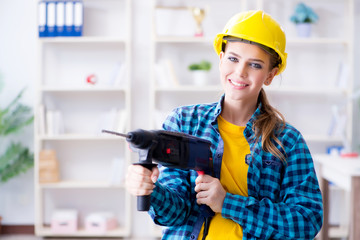 Woman in workshop with drilling drill