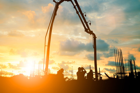 Silhouette construction industry team safely to work load concrete building according to set goal over blurred background sunset pastel for industry background.with Light fair