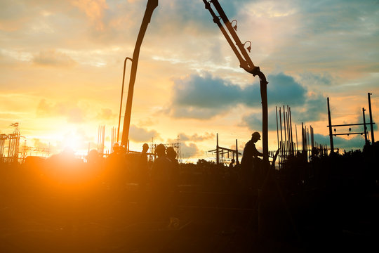 Silhouette construction industry team safely to work load concrete building according to set goal over blurred background sunset pastel for industry background.with Light fair