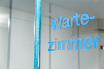 Glastür mit Aufschrift Wartezimmer, warten beim Arzt oder Amt