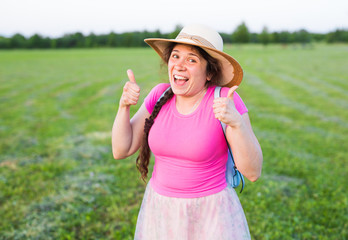 Portrait on cute funny laughing woman with freckles in hat showing thumbs up gesture